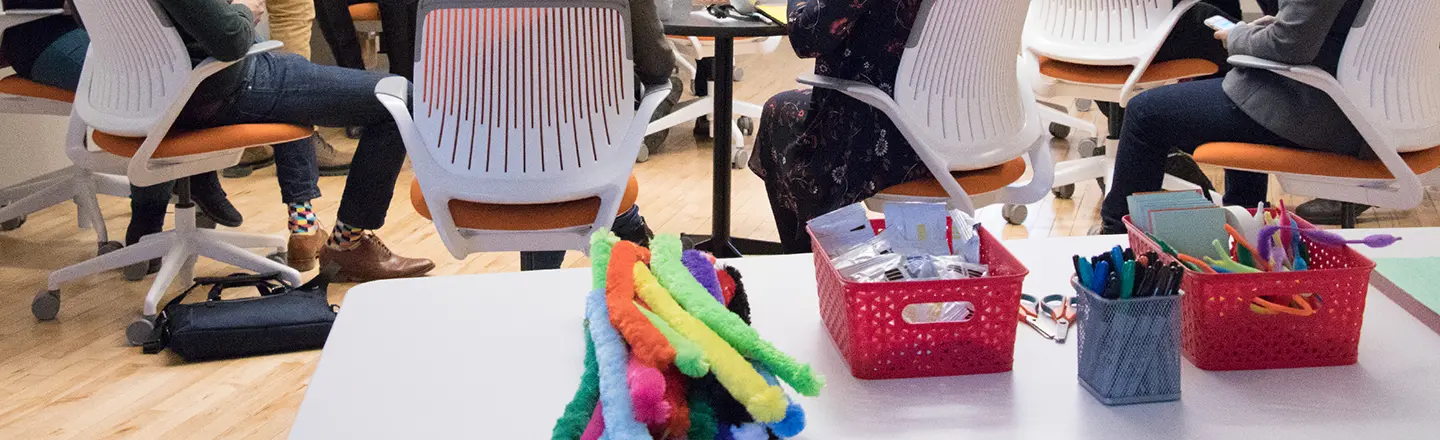 Table filled with craft materials in a design thinking workshop, representing hands-on activities that spark creativity.