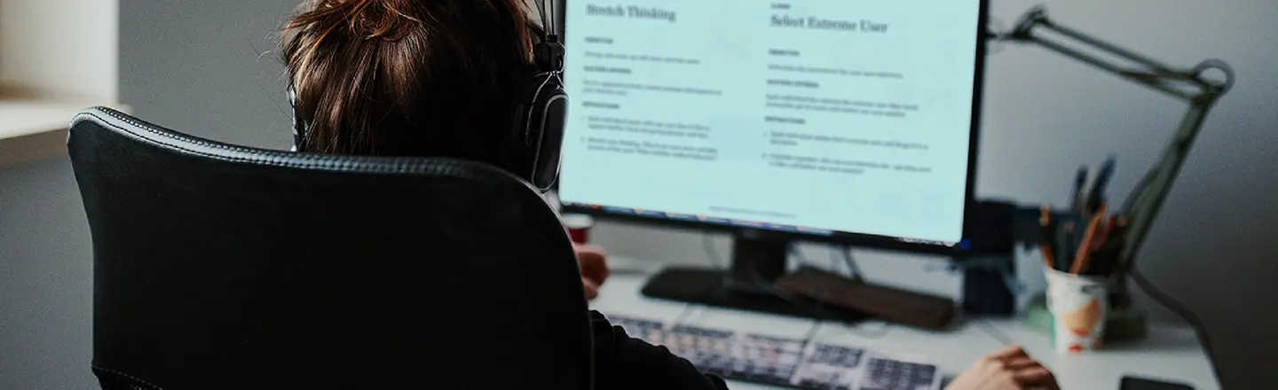 A participant using a computer with headphones, showcasing the experience of an innovation workshop.