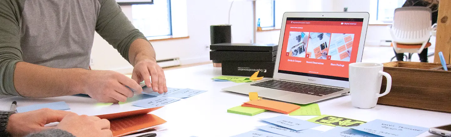 Participants using sticky notes to generate user insights in an innovation workshop.