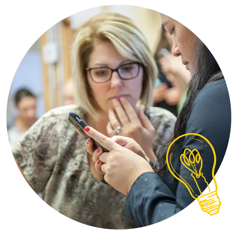 Participants collaborating over a phone, learning design thinking fundamentals in the ExperienceInnovation™ | Aware workshop.