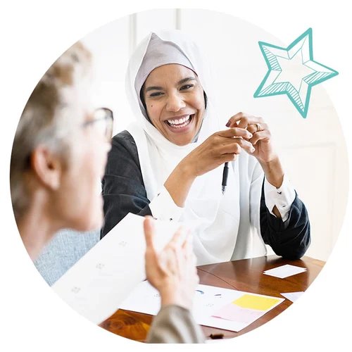 Two participants laugh together in a training program.