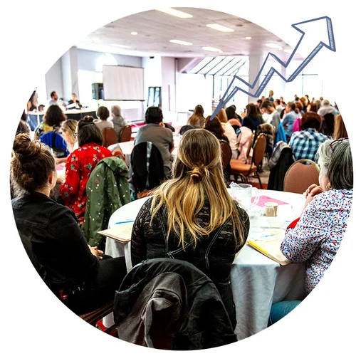 An audience sits in a crowd at a corporate event, showcasing how design thinking training brings people together.