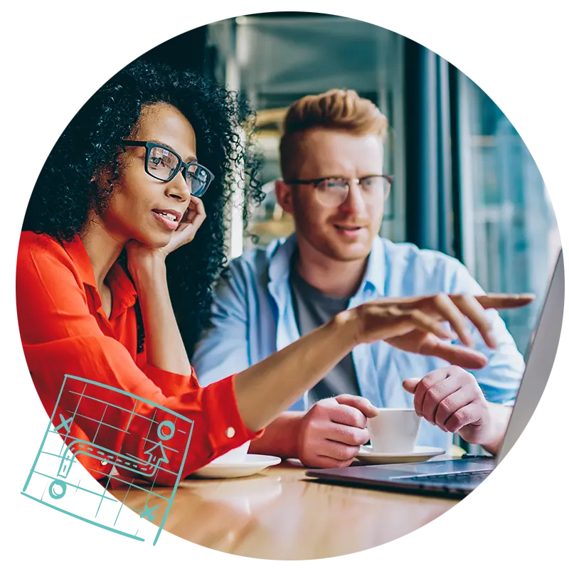 Two people sitting in front of a laptop making a plan on what use cases they an apply AI to